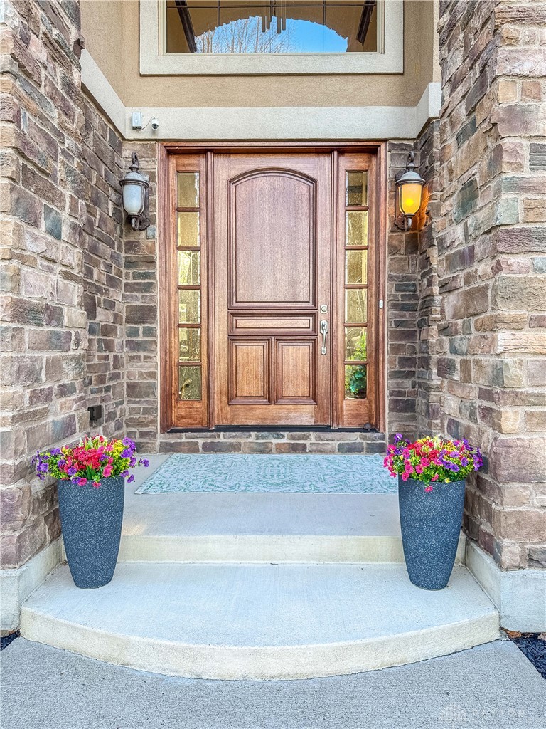 4096 Middle Urbana Road Urbana, OH 43078 - Photo 55 of 96 This inviting entrance features a rich wooden door flanked by stone accents, creating a grand approach.