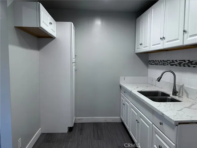 a kitchen with stainless steel appliances granite countertop white cabinets and sink