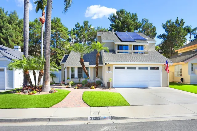 front view of house with a yard and potted plants