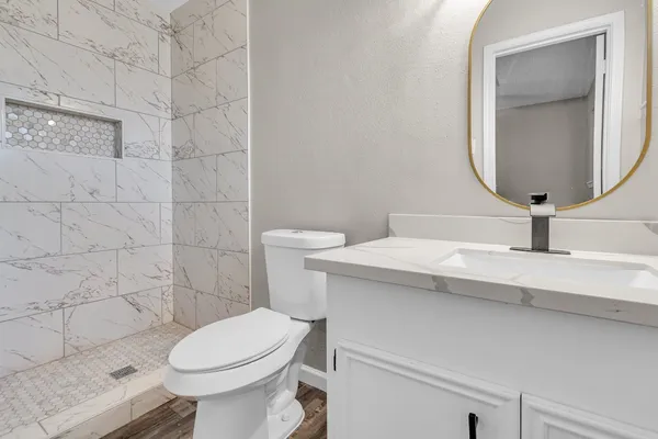a bathroom with a toilet a sink and mirror