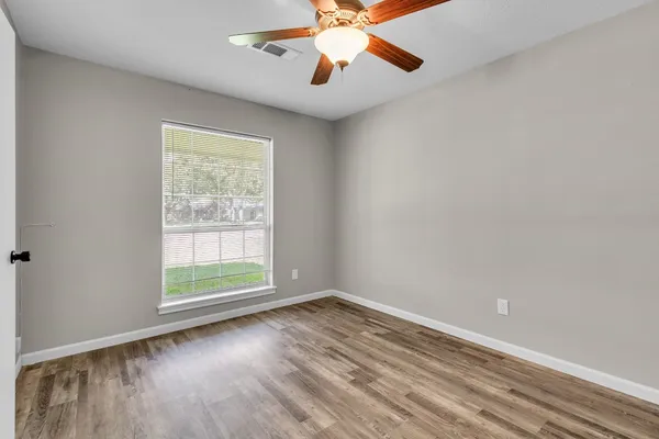 wooden floor in an empty room with a window
