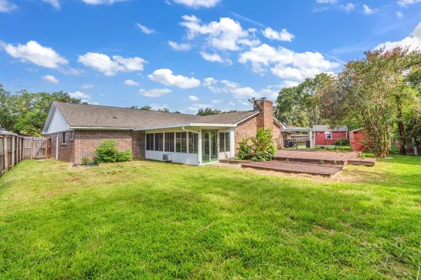 a view of a house with backyard and a tree