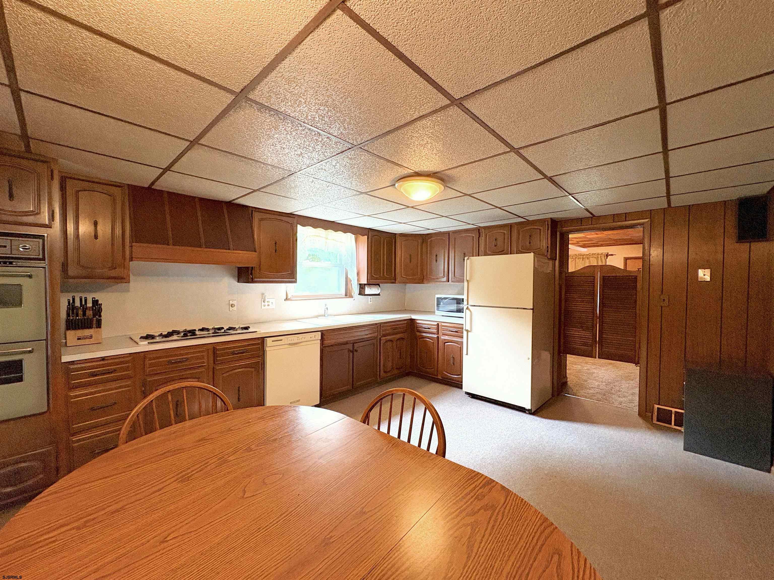 301 Broad Street Milmay, NJ 08330 - Photo 15 of 64 a kitchen with a refrigerator a stove top oven a sink dishwasher and cabinets with wooden floor