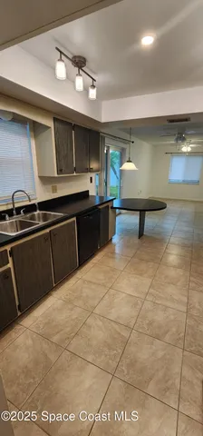a kitchen with a chandelier a sink and appliances