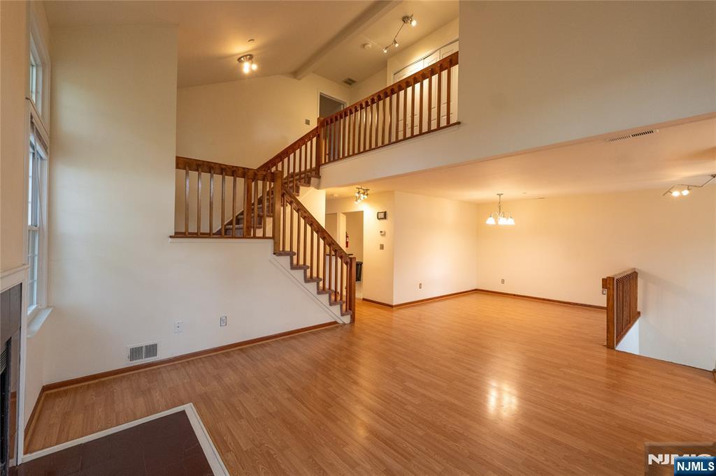 56 Fox Run Drive, Unit 56 Englewood, NJ 07631 - Photo 4 of 31 a view of an empty room with wooden floor and stairs