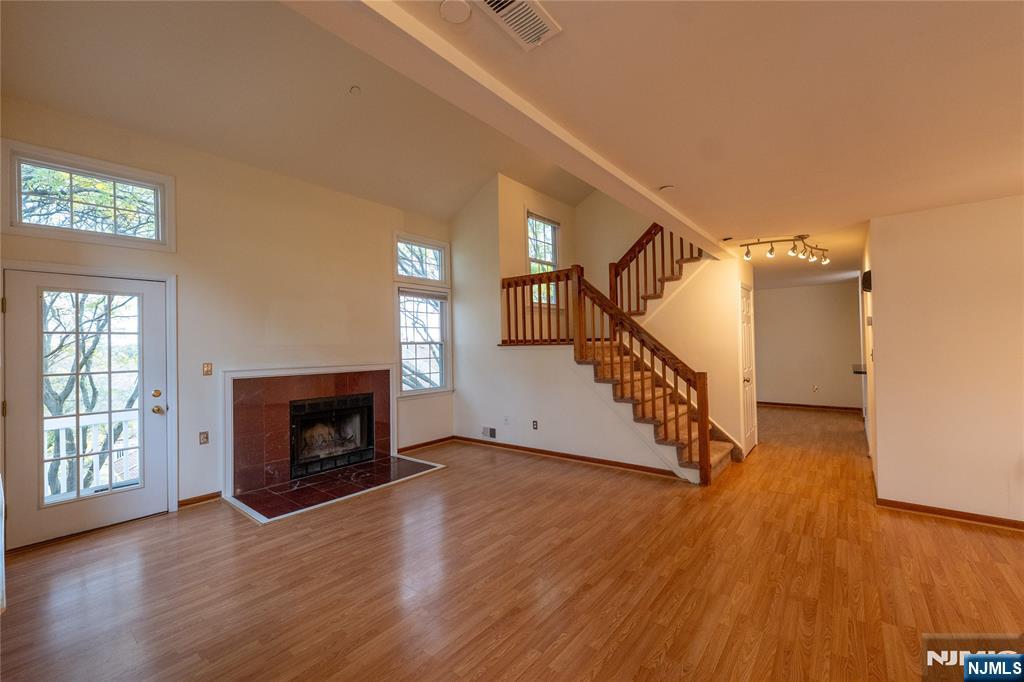 56 Fox Run Drive, Unit 56 Englewood, NJ 07631 - Photo 5 of 31 a view of empty room with wooden floor and fireplace