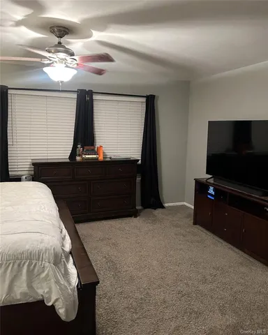 a bedroom with a bed and mirror on the dresser