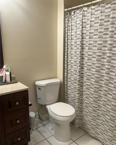 a white toilet sitting next to a white sink and vanity
