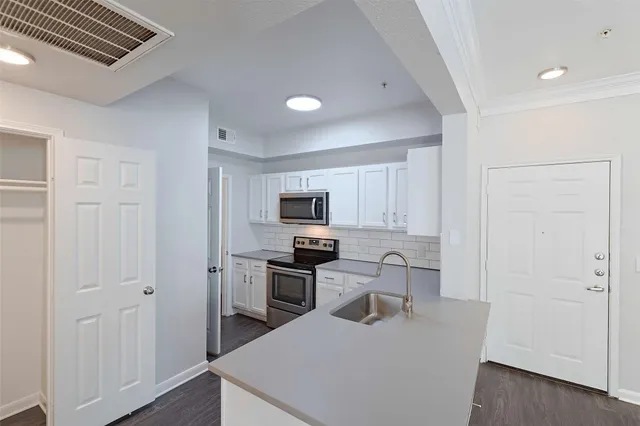 a kitchen with cabinets and stainless steel appliances