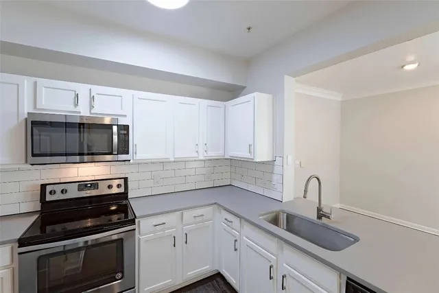 a kitchen with cabinets stainless steel appliances and a counter space