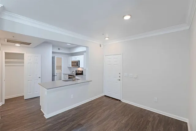 a view of a living room and kitchen with wooden floor