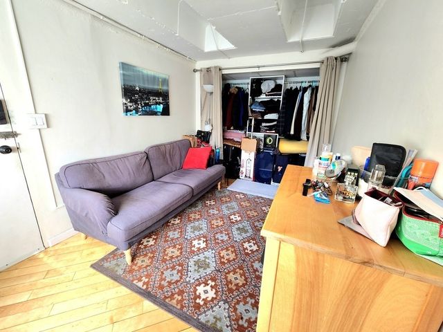 a living room with furniture a flat screen tv and a large window
