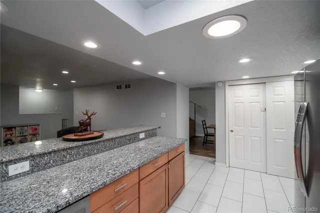 a kitchen with stainless steel appliances granite countertop a refrigerator and a sink