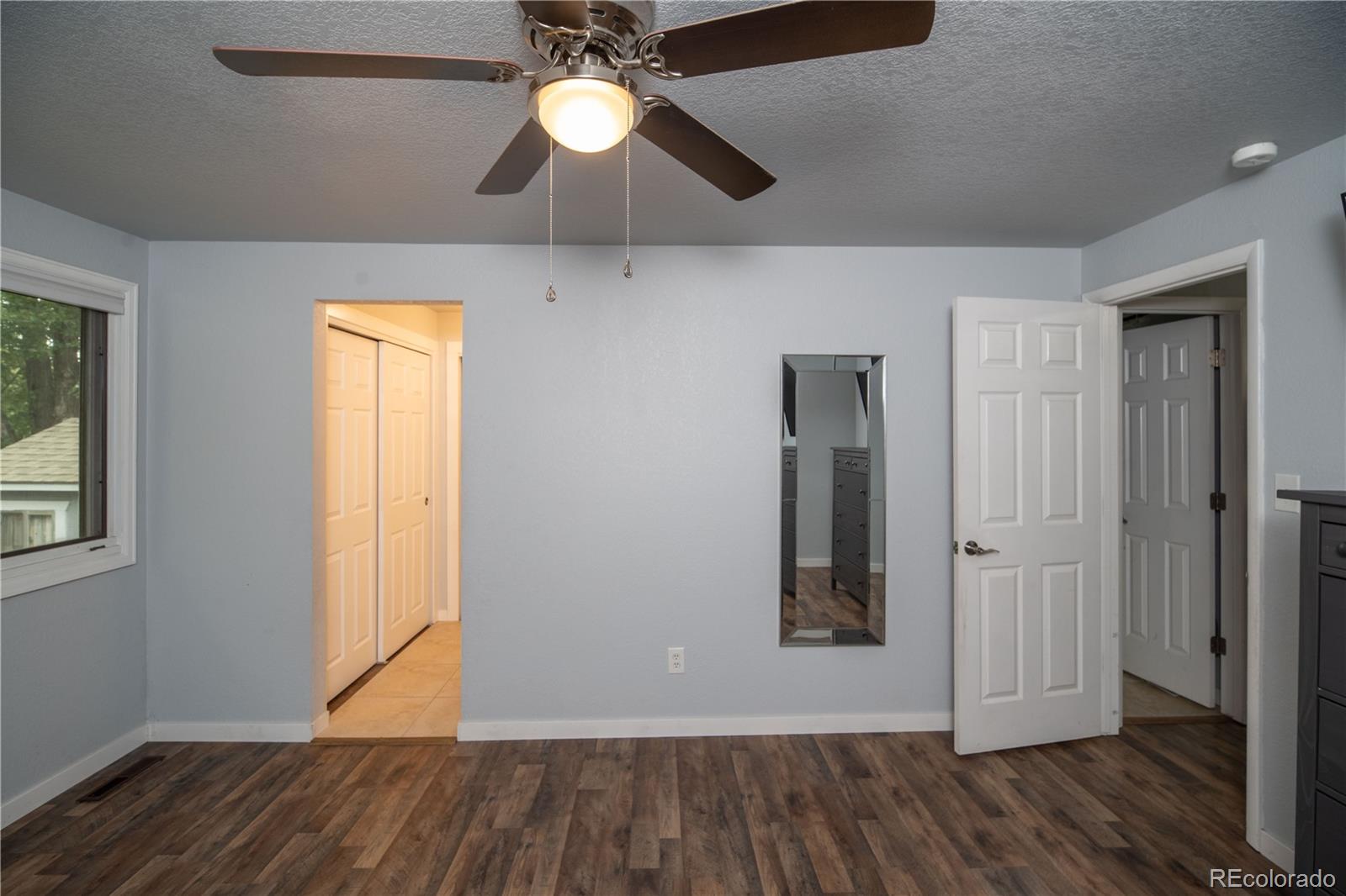 10879 West 65th Way Arvada, CO 80004 - Photo 19 of 41 an empty room with wooden floor and a ceiling fan