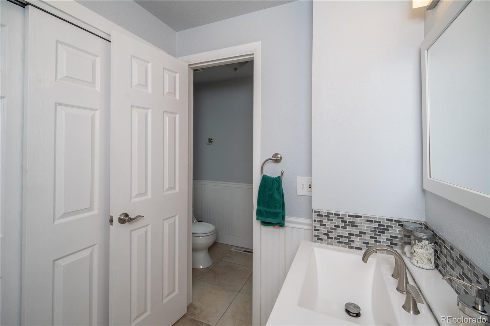 10879 West 65th Way Arvada, CO 80004 - Photo 20 of 41 a bathroom with a sink a toilet and shower