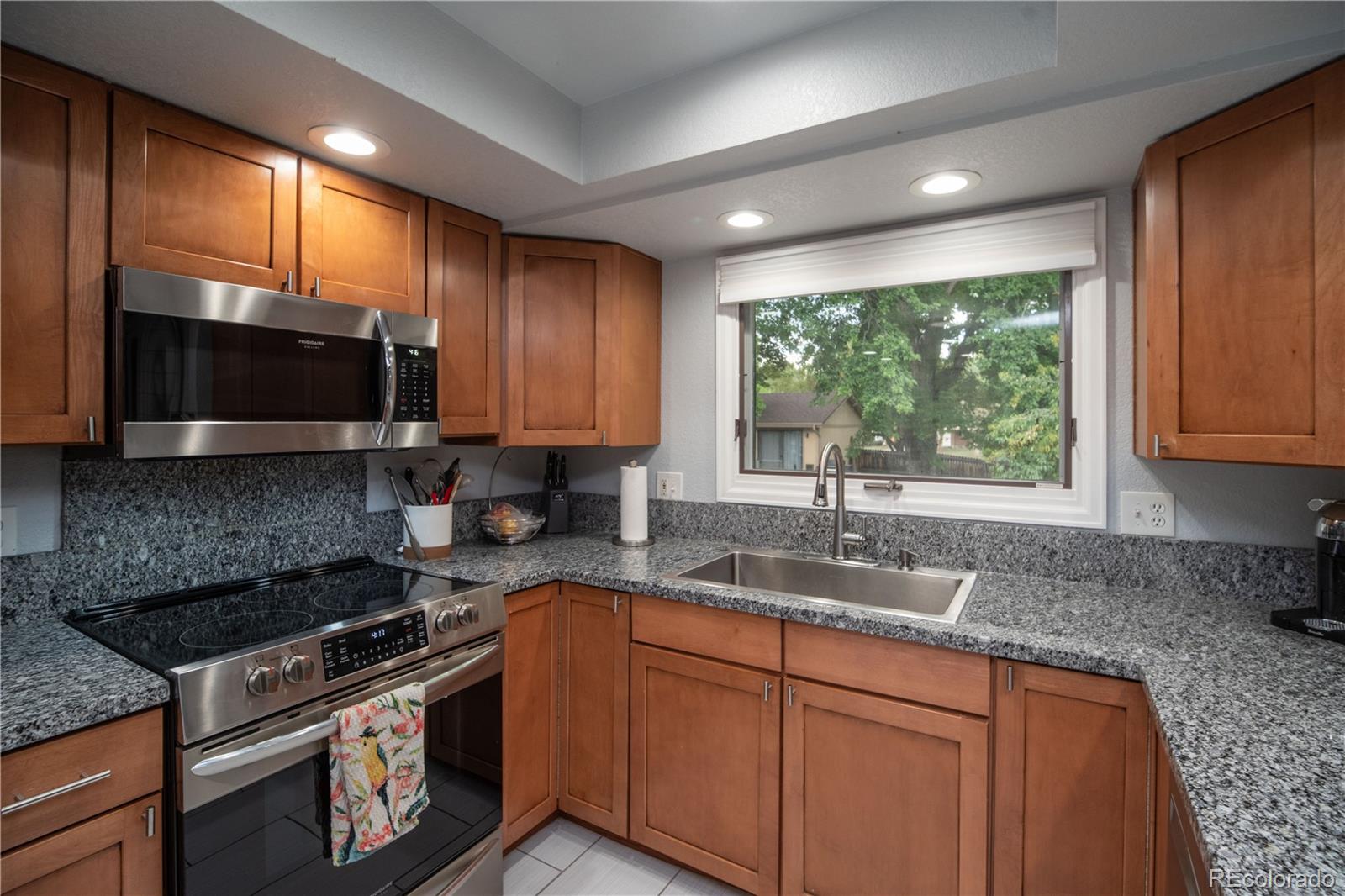 10879 West 65th Way Arvada, CO 80004 - Photo 2 of 41 a kitchen with granite countertop a sink stainless steel appliances and cabinets