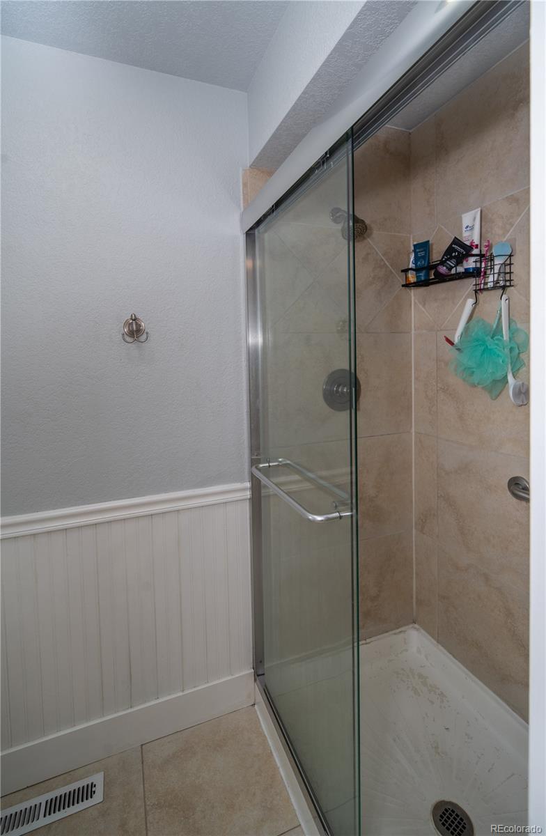 10879 West 65th Way Arvada, CO 80004 - Photo 22 of 41 a bathroom with a glass shower door
