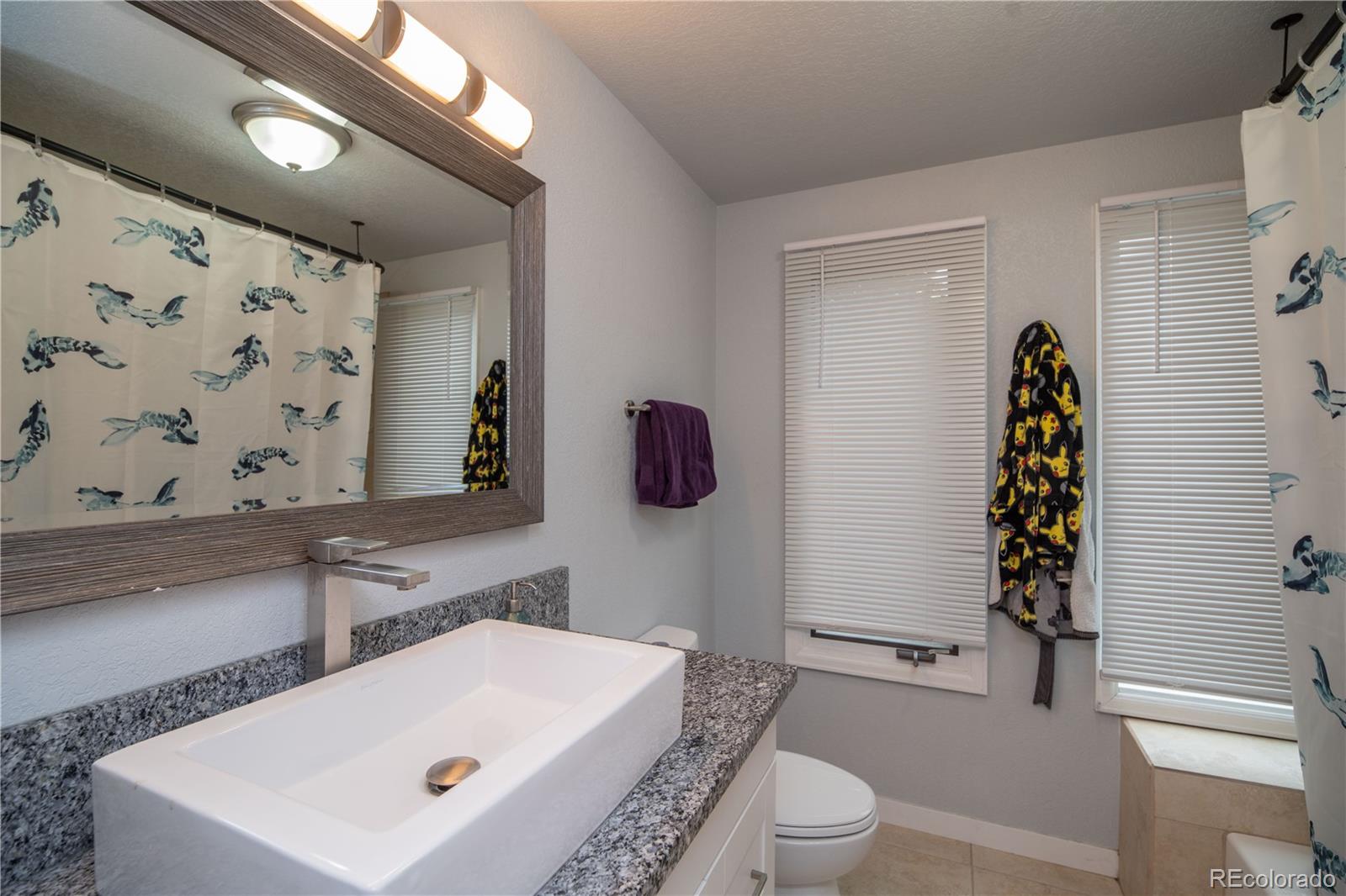 10879 West 65th Way Arvada, CO 80004 - Photo 25 of 41 a bathroom with a sink a toilet and shower