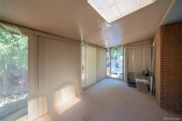 a view of an empty room with wooden floor and doors