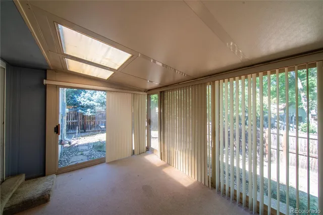 a view of a backyard with wooden fence and a large tree