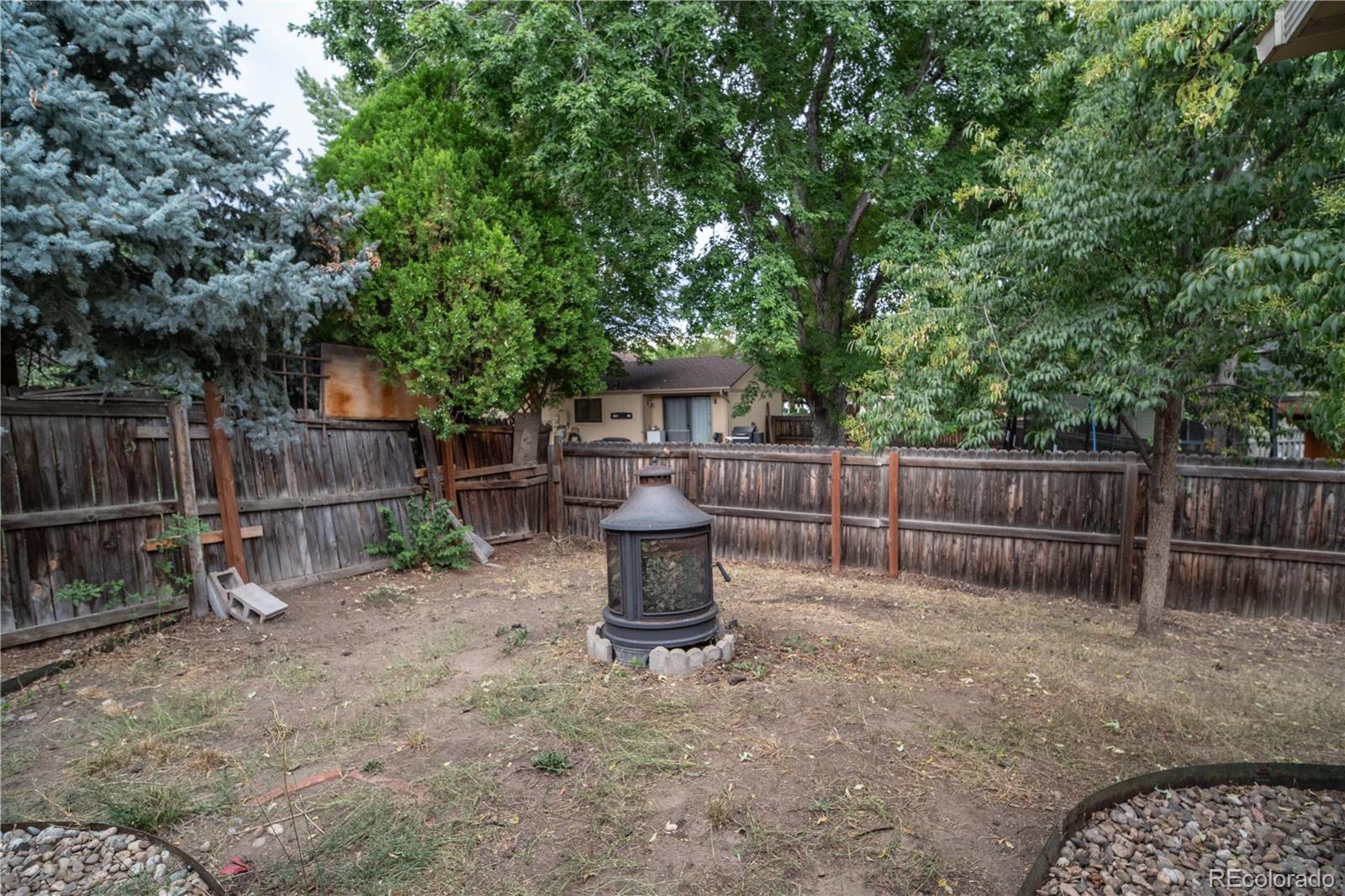 10879 West 65th Way Arvada, CO 80004 - Photo 36 of 41 a view of a backyard with wooden fence and a large tree