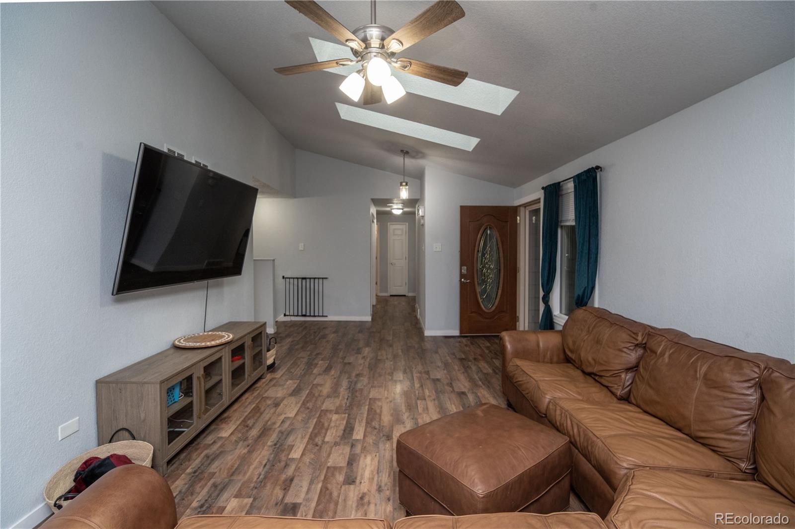 10879 West 65th Way Arvada, CO 80004 - Photo 7 of 41 a living room with furniture and a flat screen tv