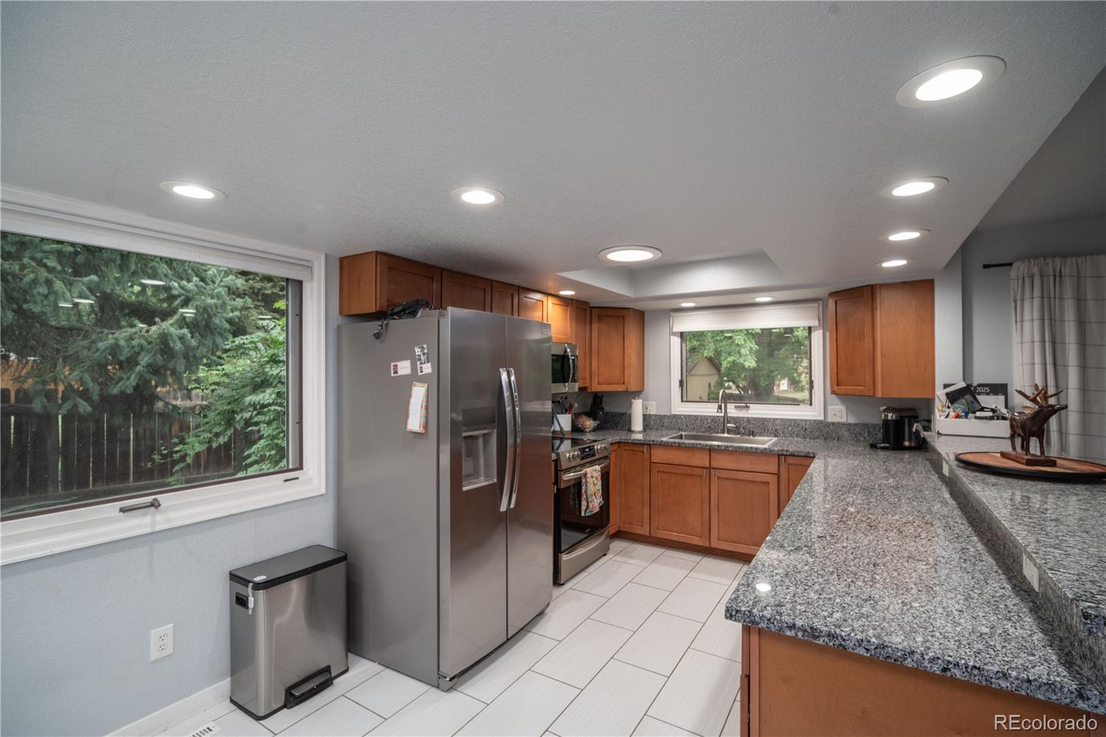 10879 West 65th Way Arvada, CO 80004 - Photo 10 of 41 a kitchen with refrigerator and microwave