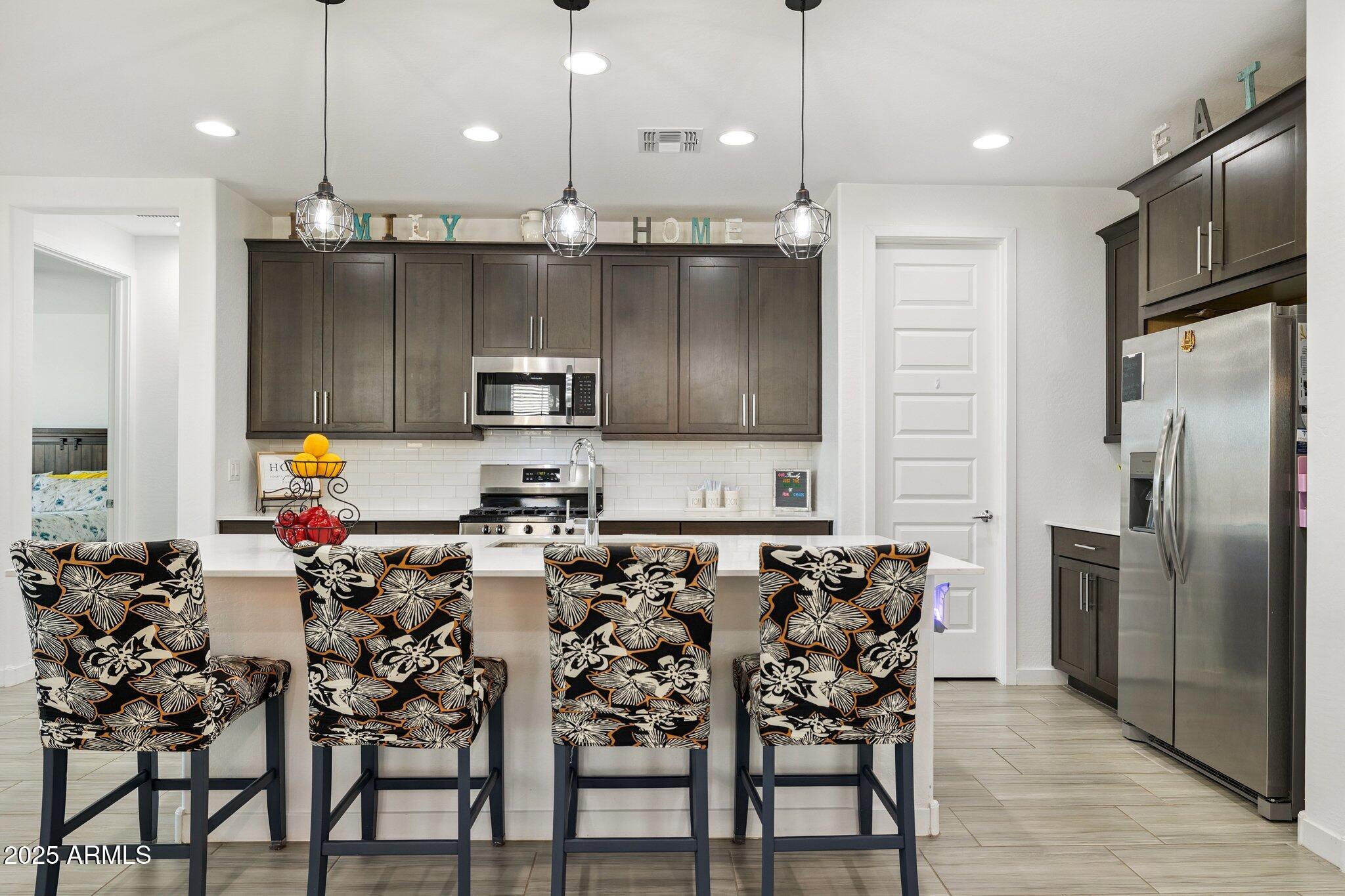 12347 East Soloman Road Gold Canyon, AZ 85118 - Photo 9 of 51 a kitchen with stainless steel appliances granite countertop a stove top oven a refrigerator and chairs