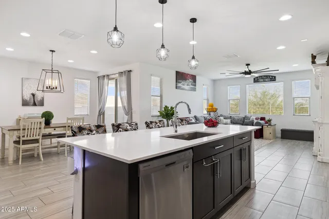 a kitchen with stainless steel appliances granite countertop a stove top oven a refrigerator and chairs