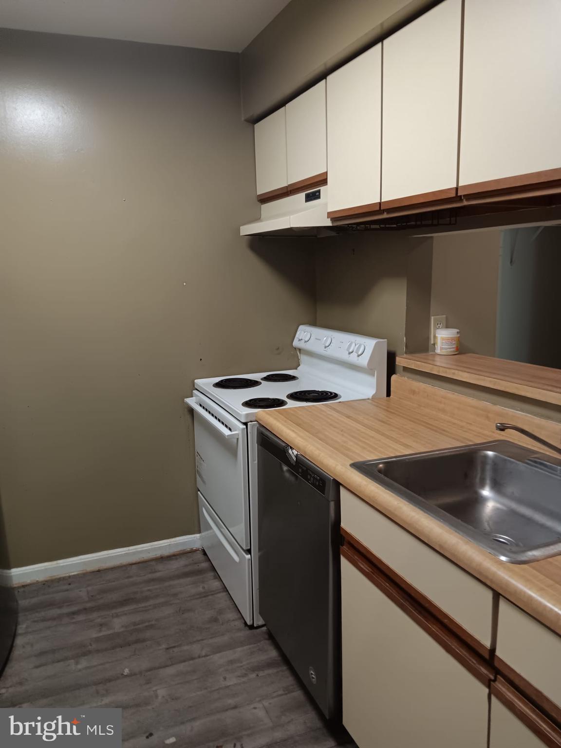 1647 Carriage House Terrace, Unit 1647C Silver Spring, MD 20904 - Photo 10 of 25 a view of a kitchen with granite countertop white cabinets and a wooden floor