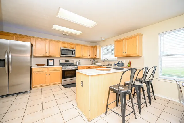 a kitchen with stainless steel appliances granite countertop a stove a sink and a refrigerator