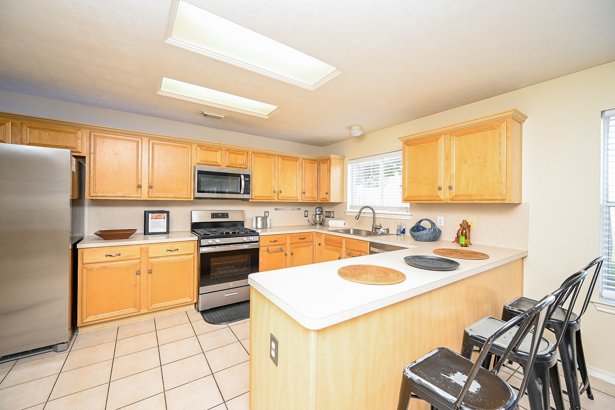 12122 Lucky Meadow Drive Tomball, TX 77375 - Photo 13 of 32 a kitchen with a stove a sink and a refrigerator