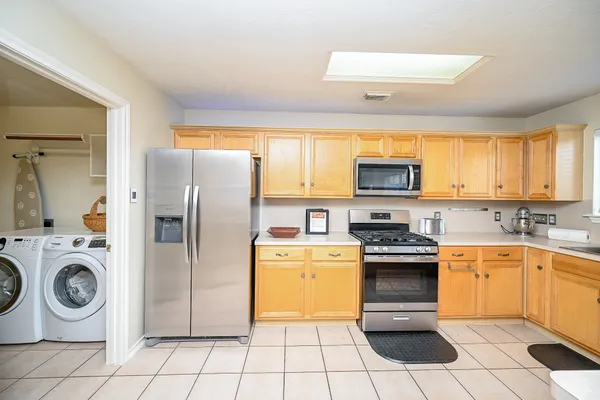 a kitchen with stainless steel appliances granite countertop a stove a sink and a refrigerator
