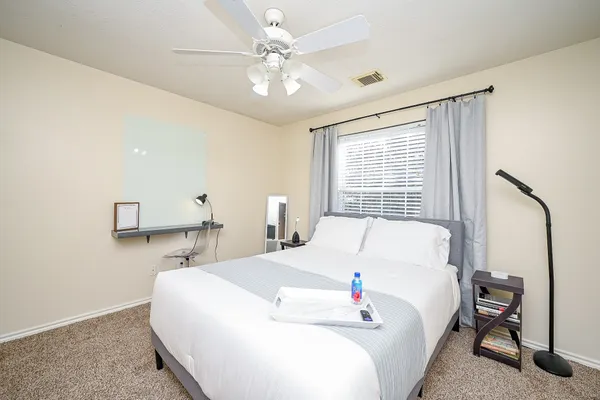 a bed sitting in a bedroom next to a window