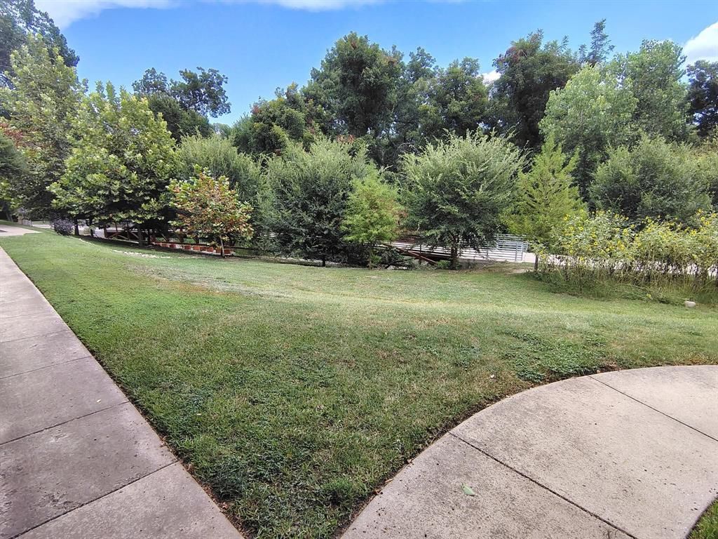 6900 Skillman Street, Unit 404 Dallas, TX 75231 - Photo 6 of 10 View of green lawn with view of wooded area