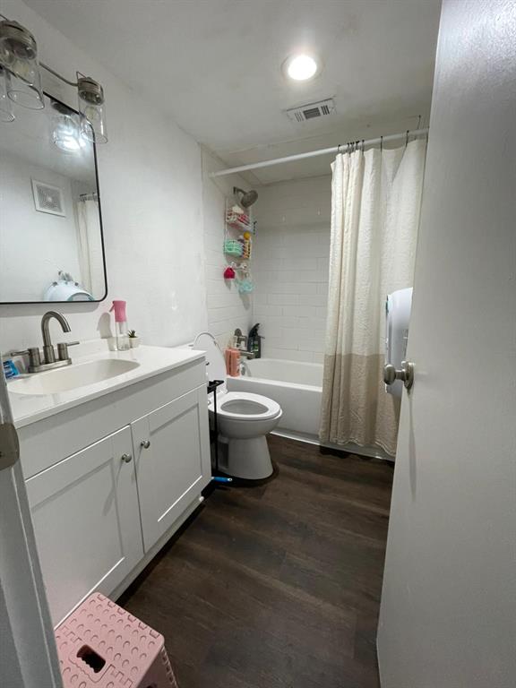 6900 Skillman Street, Unit 404 Dallas, TX 75231 - Photo 10 of 10 Full bathroom featuring dark wood-type flooring, vanity, and shower / tub combo
