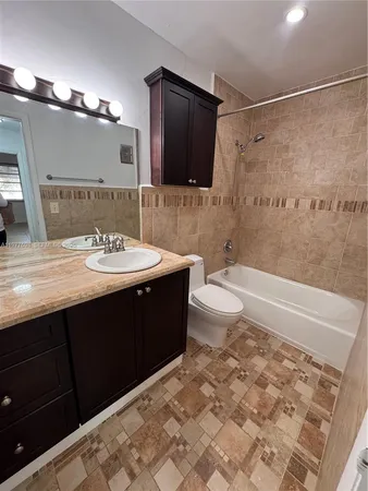 a bathroom with a sink a toilet a mirror and shower