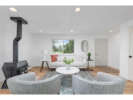 a living room with furniture a potted plant and a large window