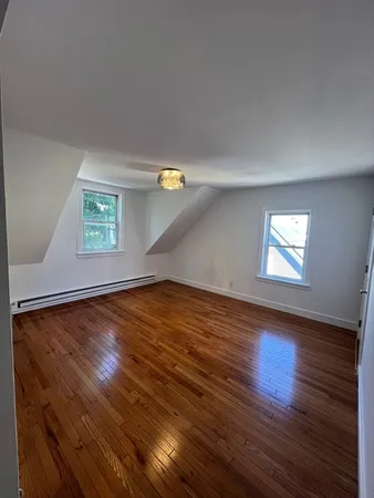 a view of empty room with window and wooden floor