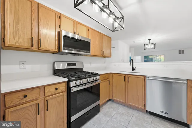 a kitchen with stainless steel appliances granite countertop a sink a stove a microwave and cabinets