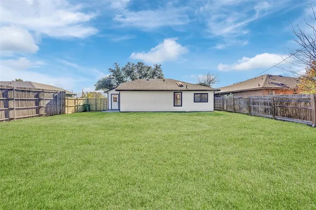 a view of a house with a big yard and large trees