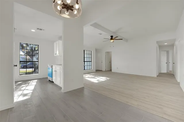 a view of empty room with wooden floor and window