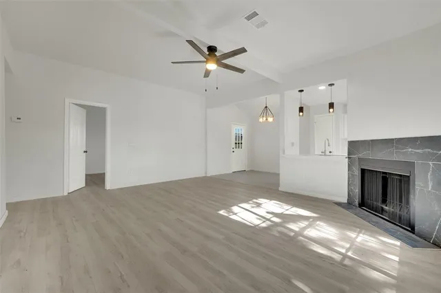 a view of a livingroom with a fireplace ceiling fan and window
