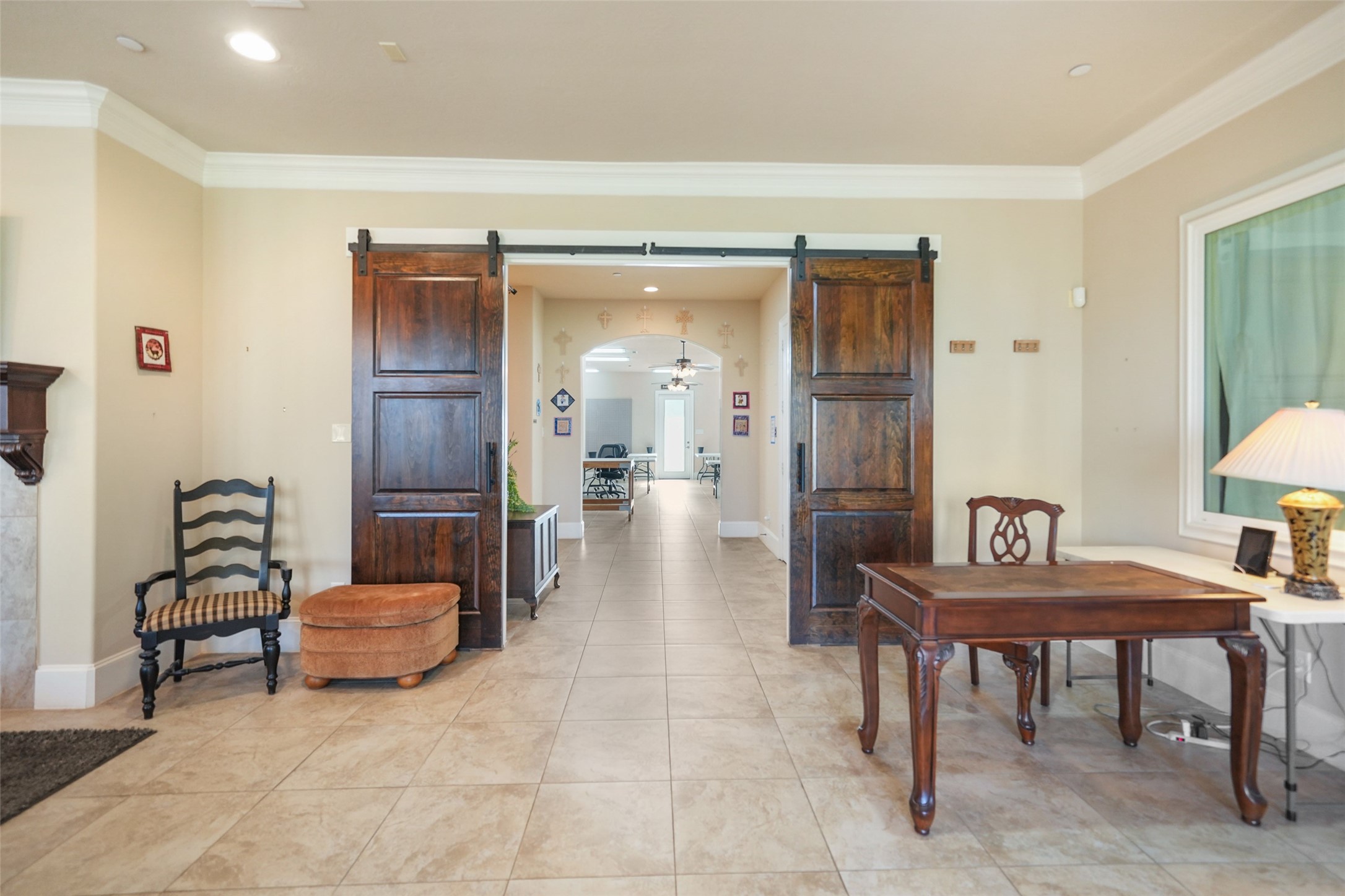 26250 B Riley Road Waller, TX 77484 - Photo 9 of 45 Inviting front entry with wide tile flooring, crown molding, and double wood barn doors opening to the main hallway and activity areas.