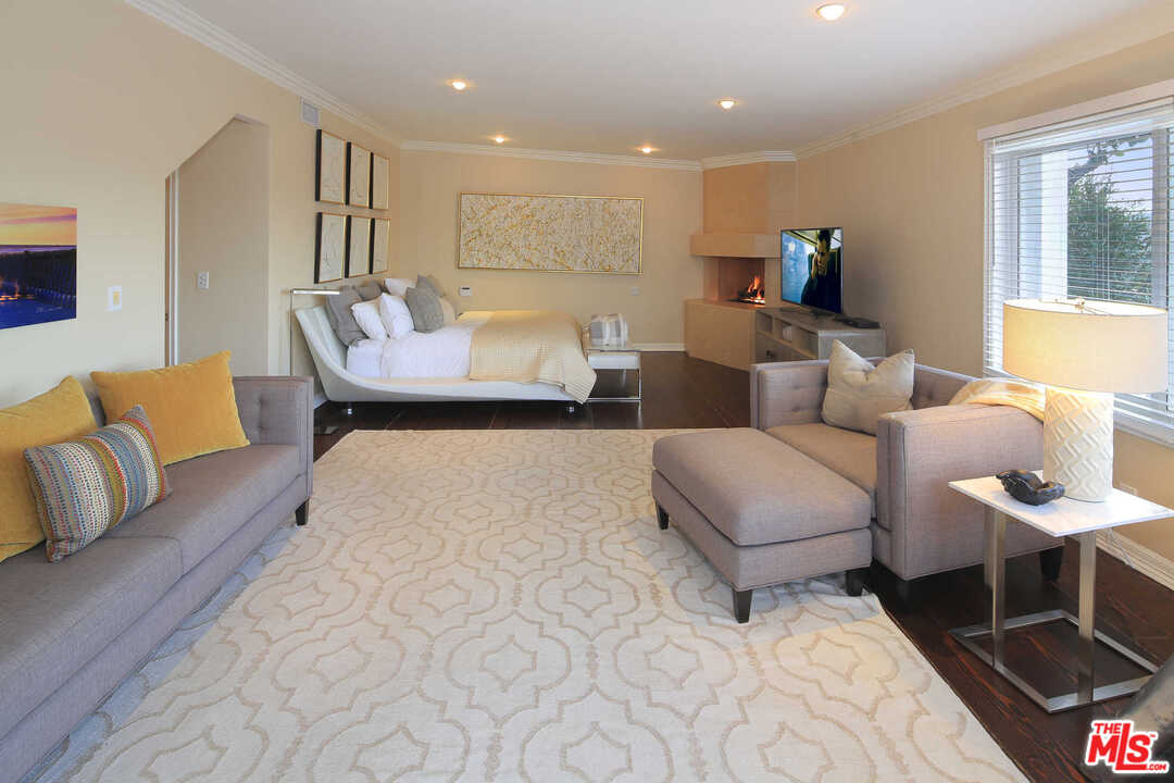 1410 Stradella Road Los Angeles, CA 90077 - Photo 12 of 24 a spacious bedroom with a bed a couch and a dresser with wooden floor