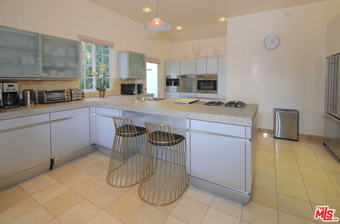 1410 Stradella Road Los Angeles, CA 90077 - Photo 13 of 24 a kitchen with a sink and cabinets