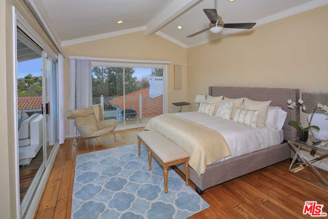1410 Stradella Road Los Angeles, CA 90077 - Photo 10 of 24 a bedroom with a bed and wooden floor