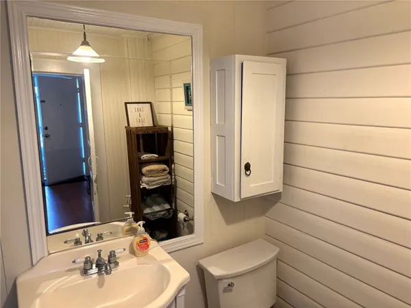 a bathroom with a toilet sink and mirror