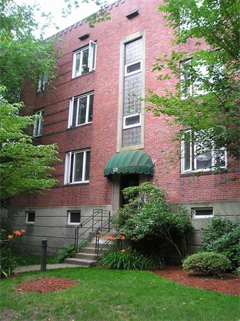 128 Beaconsfield Road, Unit 1 Brookline, MA 02445 - Photo 1 of 16 a front view of a house with a yard and plants