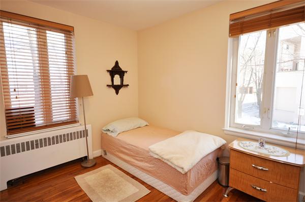 128 Beaconsfield Road, Unit 1 Brookline, MA 02445 - Photo 8 of 16 a bedroom with a bed and a window with wooden floor
